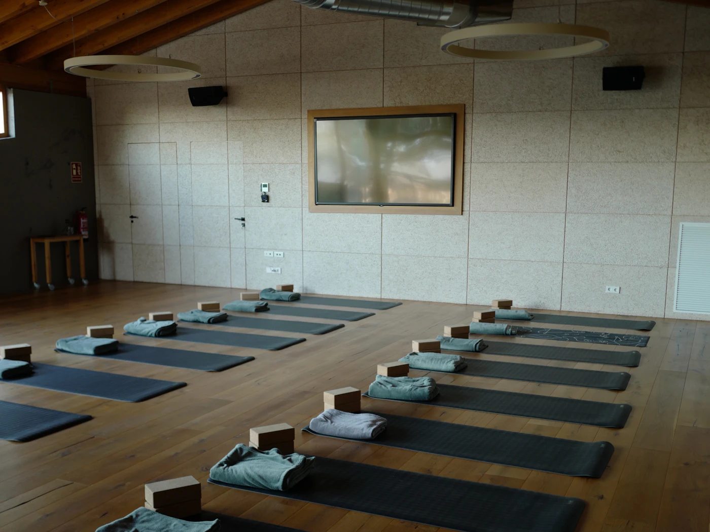 Sala de yoga con esterillas preparadas sobre suelo de madera (imagen ilustrativa)